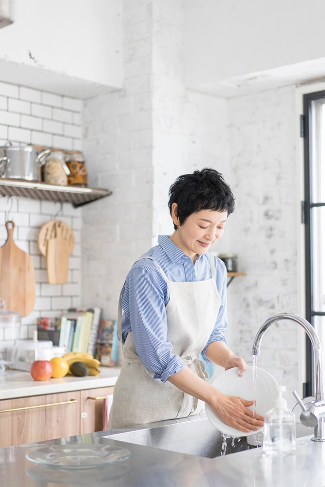 エプロン姿で家事をサポートするスタッフ