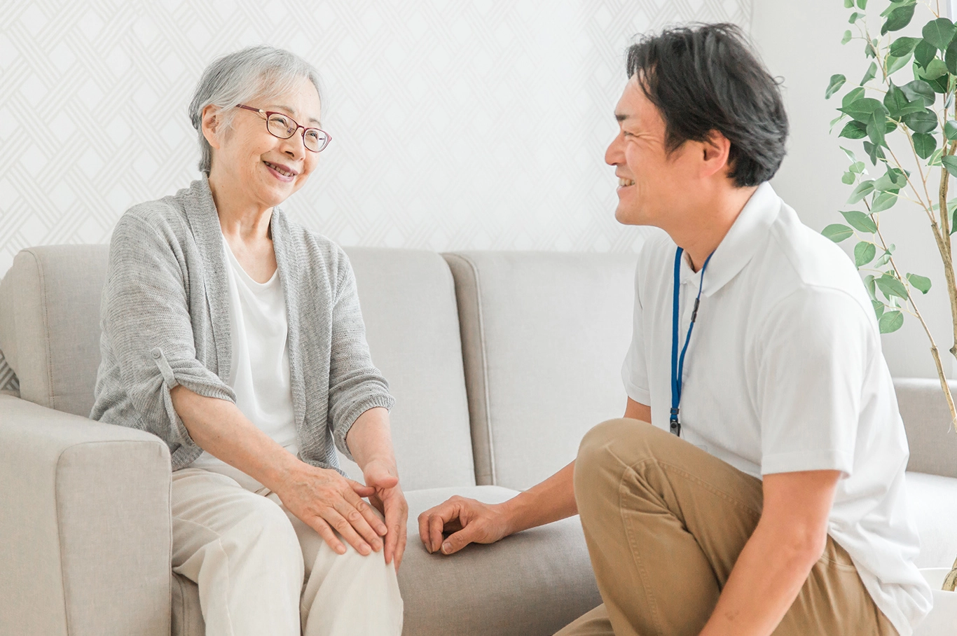 高齢女性と笑顔で会話するスタッフ