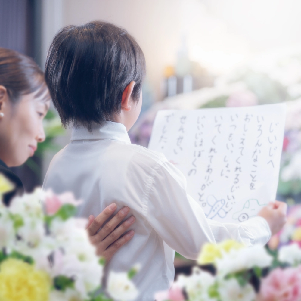 祭壇の前で手紙を読む子どもと寄り添う母親