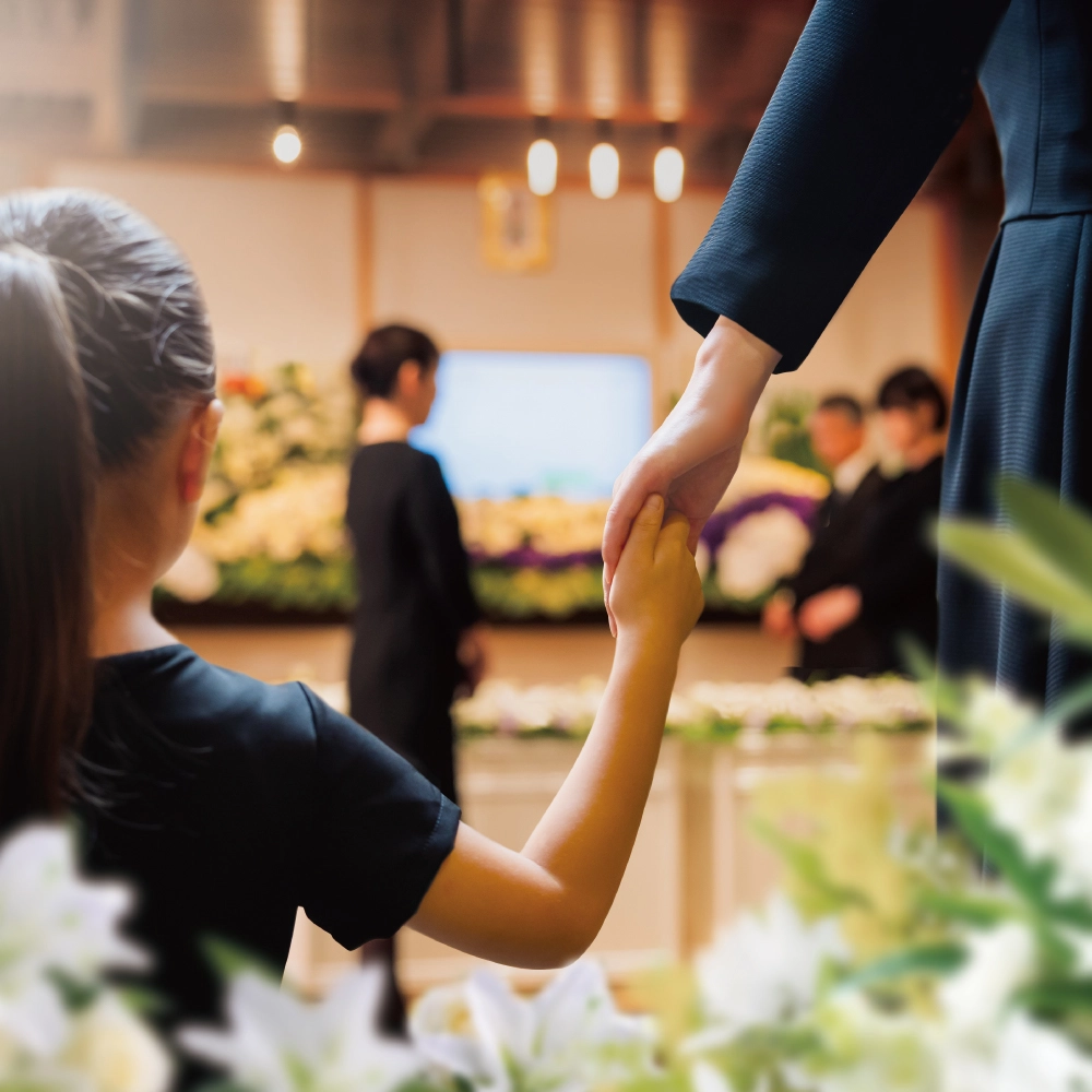 祭壇の前で手をつなぐ母親と子ども